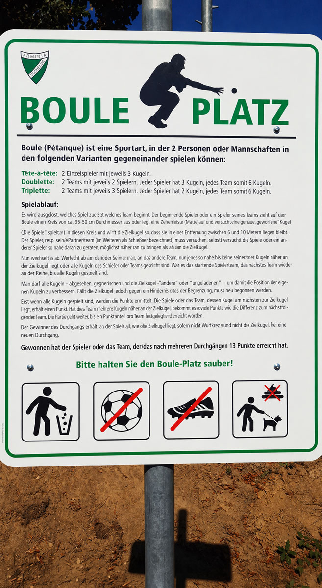 Hinweisschild mit Spielvarianten und Regeln fuer den Bouleplatz